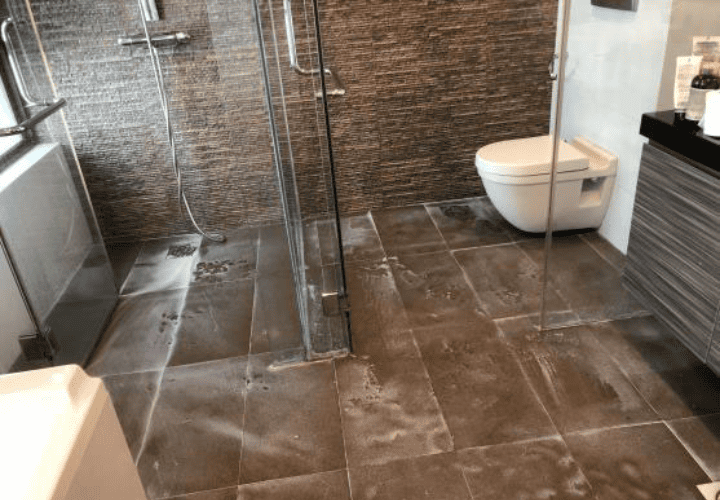 Technician inspecting a bathroom ceiling for water damage during Hydroseal360 waterproofing service